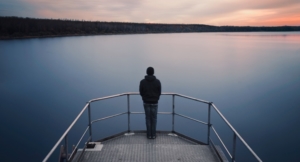 young man standing on lake